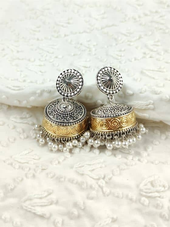 Silver and gold jhumka earrings on lace
